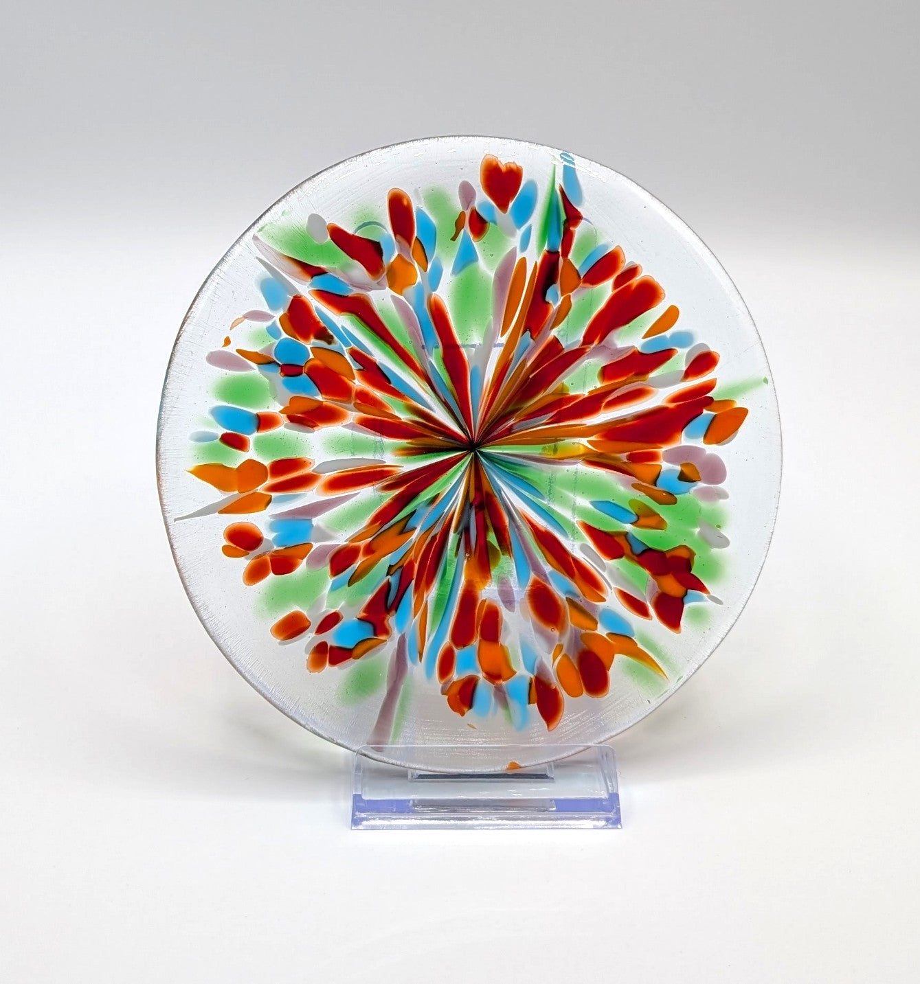 Colorful circular artwork with a radial pattern on a white background