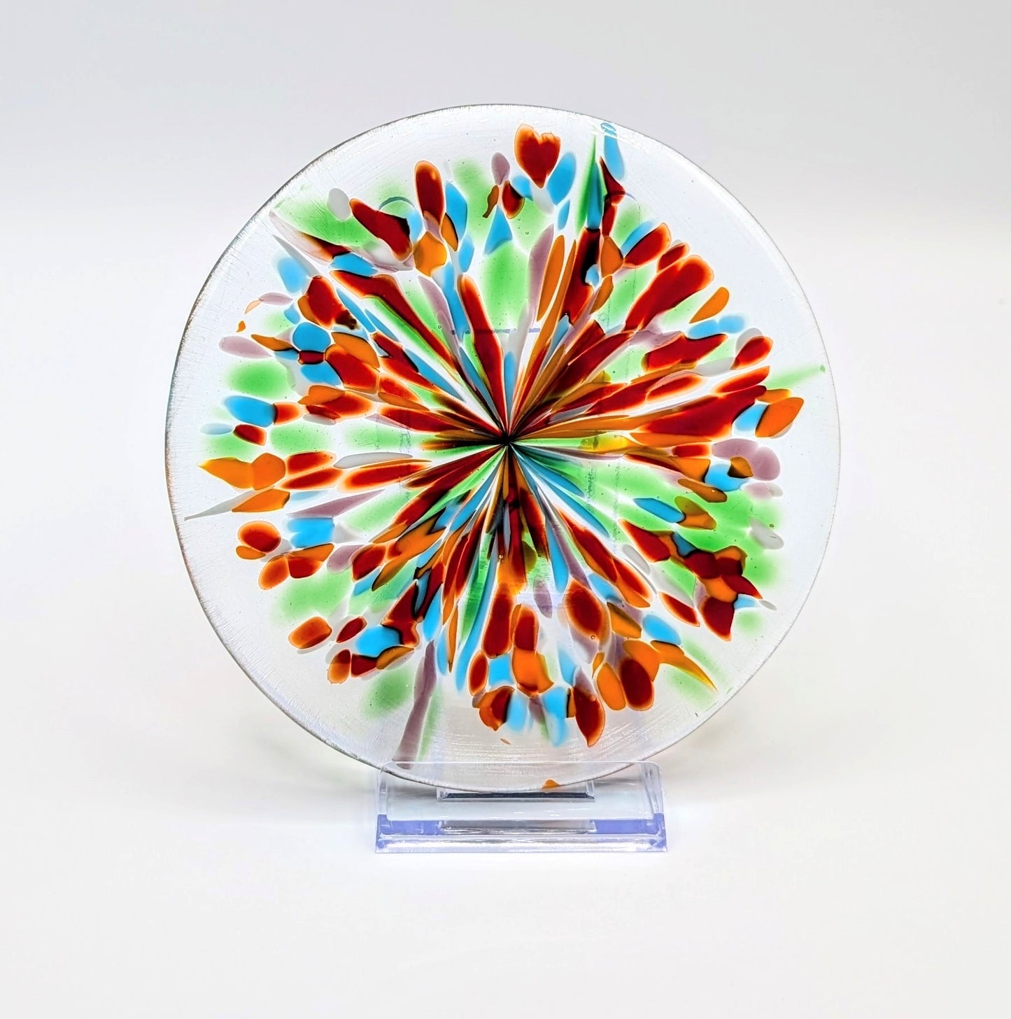 Colorful glass plate with a starburst pattern on a white background